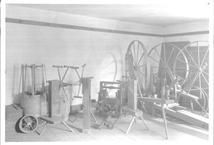 SA0662 - Photo shows wool wheels, yarn winders, and other spinning equipment.
